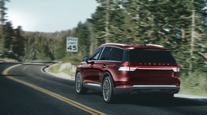 A 2024 Lincoln Aviator® SUV is being driven on a winding mountain road | Angela Krause Lincoln of Alpharetta in Alpharetta GA