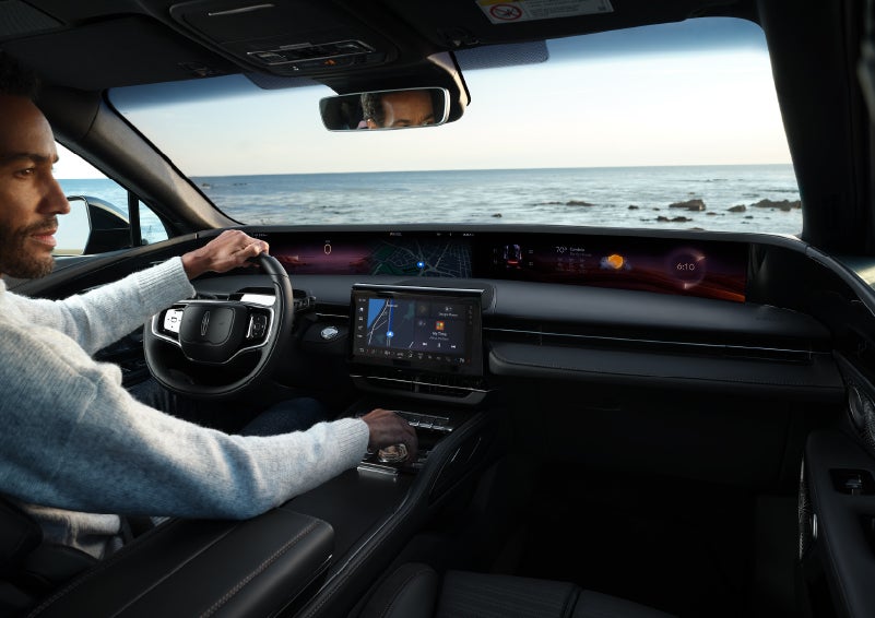 A driver of a parked 2024 Lincoln Nautilus® SUV takes a relaxing moment at a seaside overlook while inside his Nautilus. | Angela Krause Lincoln of Alpharetta in Alpharetta GA